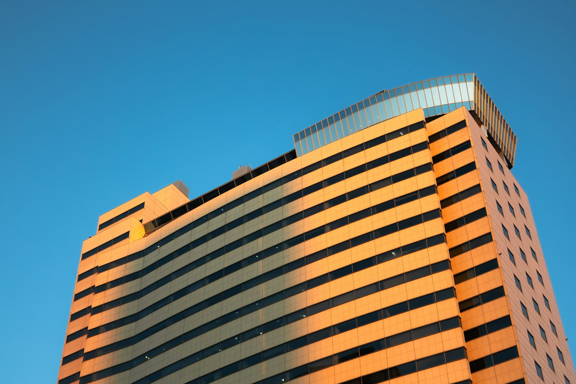 Tour de bureaux à la façade orange sur ciel bleu
